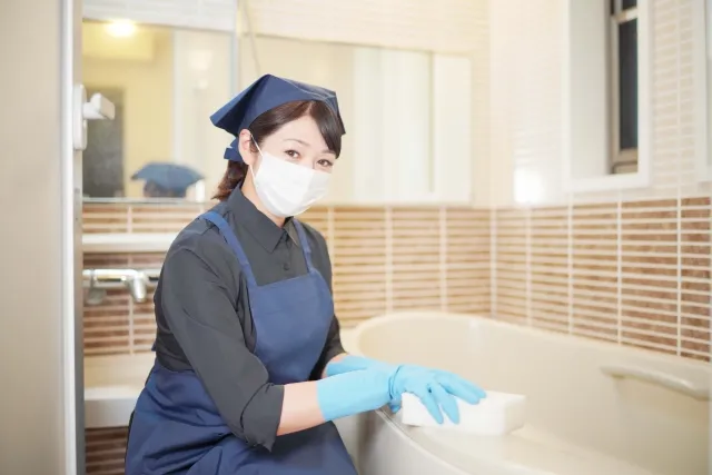 風呂場を掃除する女性